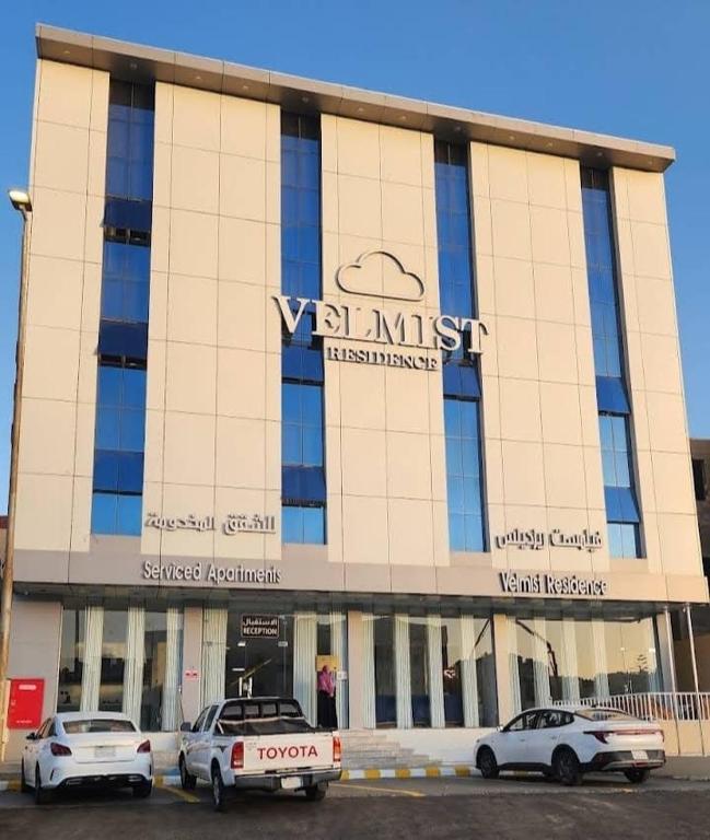 two cars parked in a parking lot in front of a building at فيلمست ريزيدنس ابهاVelmist Residence Abha in Abha
