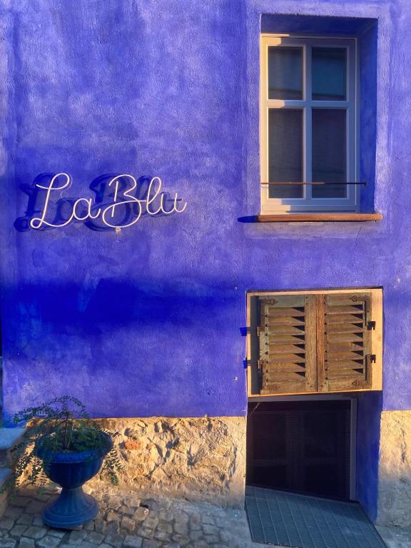 a purple wall of a building with a window at La Blu di Via Silvano 8 in Monforte dʼAlba