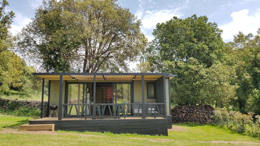 a small house with a deck in the grass at Casa Prunelli in Bastelicaccia
