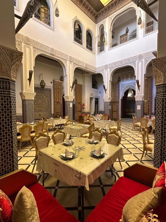 a restaurant with tables and chairs in a room at Riad Fes Bab Rcif Suite &Spa in Fez