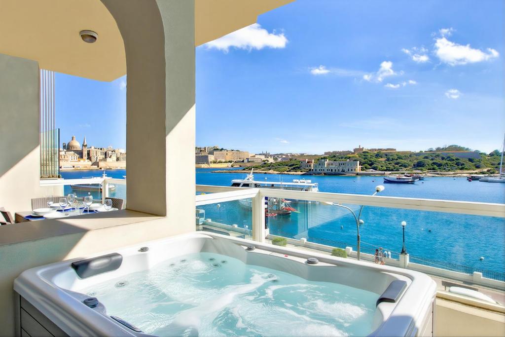 a bath tub with a view of the water at Tigné Seafront Apartments & Penthouse with Heated Jacuzzi in Sliema