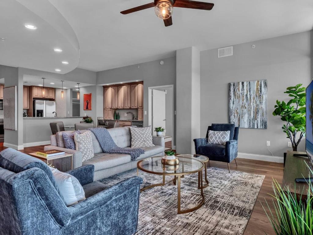a living room with blue furniture and a ceiling fan at Luxurious Penthouse with large patio in Orlando