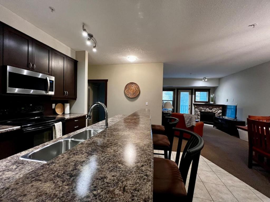 a kitchen with a counter top and a living room at 2 Bed 2 Bath with Fire Place in Fernie