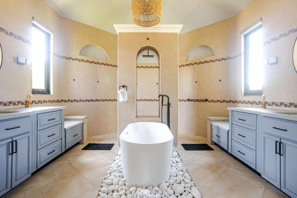 a bathroom with two sinks and a bath tub at Spacious House with Pool and BBQ in Arenales