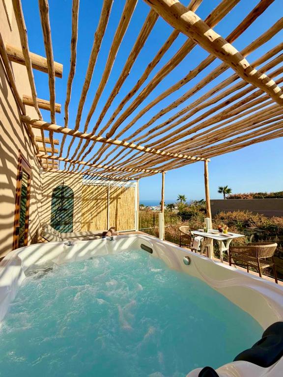 a hot tub under a wooden pergola at Apartamentos Finca RiscoTierra in Arafo