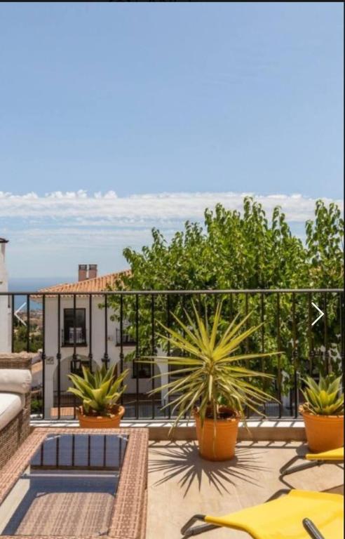 a balcony with plants and a view of the ocean at Duplex Apartman with sunny terrace in Mijas Pueblo in Mijas