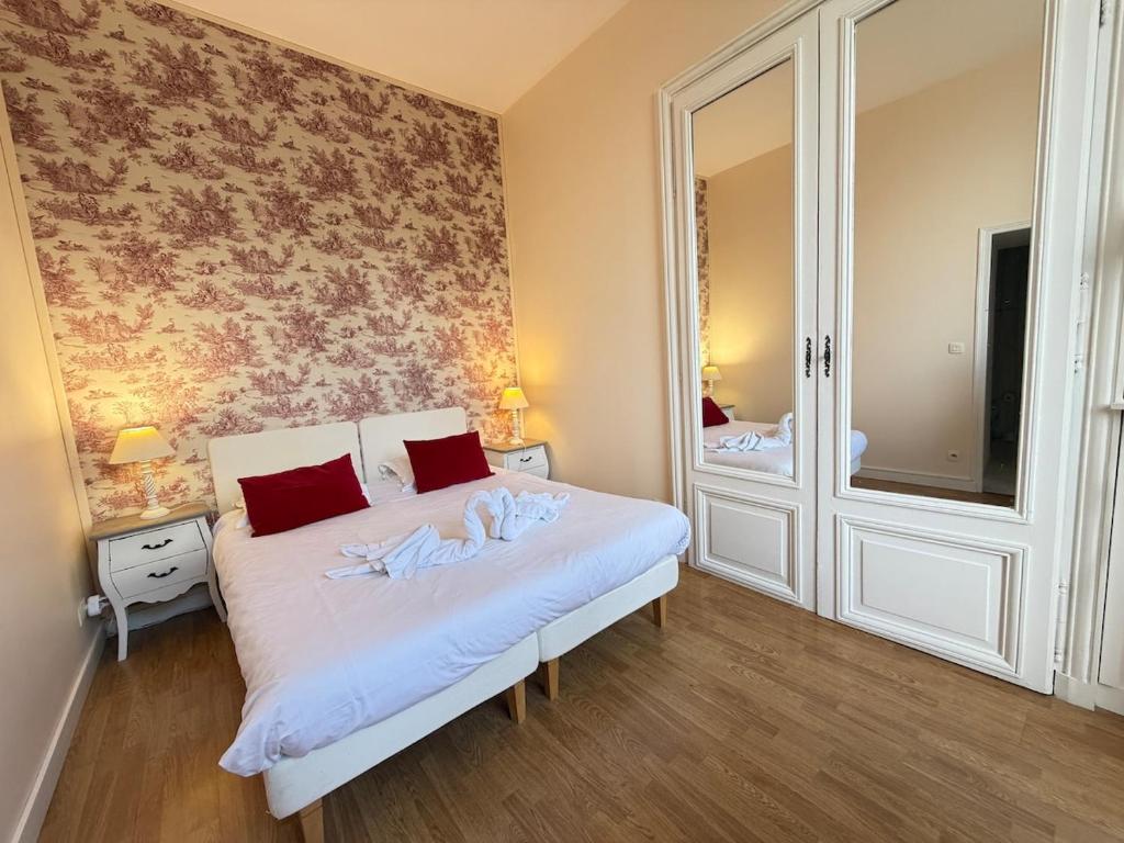 a bedroom with a white bed with a mirror at Studio au château in Monchy-Humières