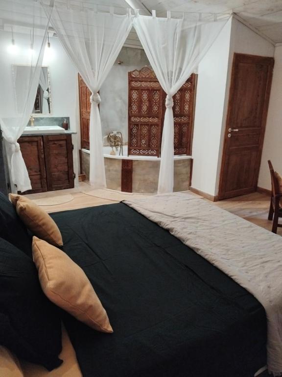a bedroom with a large bed and a bathroom at Côté fontaine in Orange