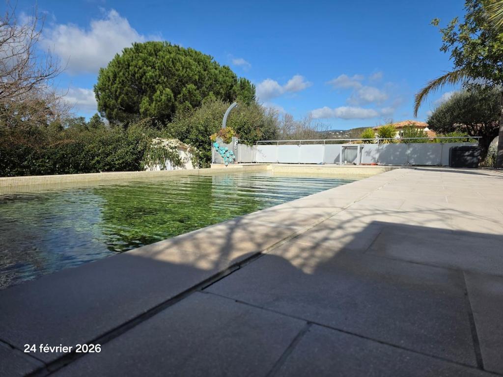 a pool of water in a yard with a fountain at Spacieuse villa au calme avec grande piscine in Bormes-les-Mimosas