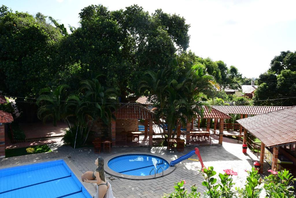 a backyard with a pool and a house with trees at Hotel Serrano Martins in Martins