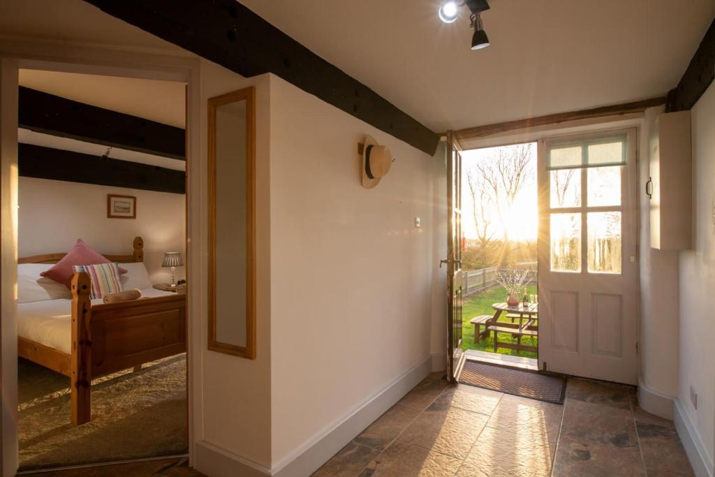 a bedroom with a bed and a sliding glass door at Bryn Lon in Caeʼr-geiliog