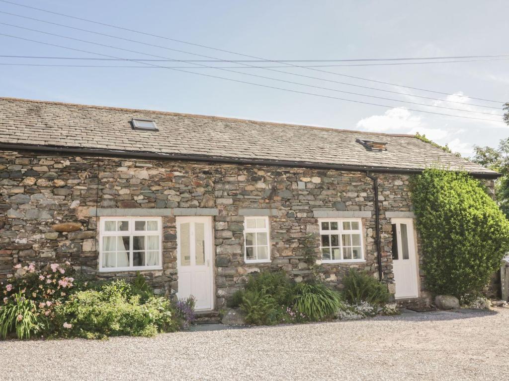 a stone cottage with white doors and windows at Cottage 1 in Keswick