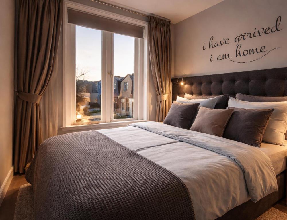 a bedroom with a large bed and a window at Bed and Breakfast The Rose in Haarlem