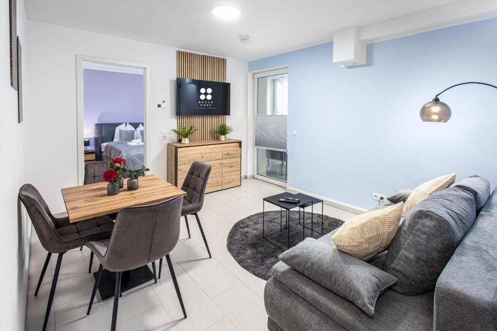 a living room with a couch and a table at BrockHeus Riverside Aparthotel Magdeburg in Magdeburg