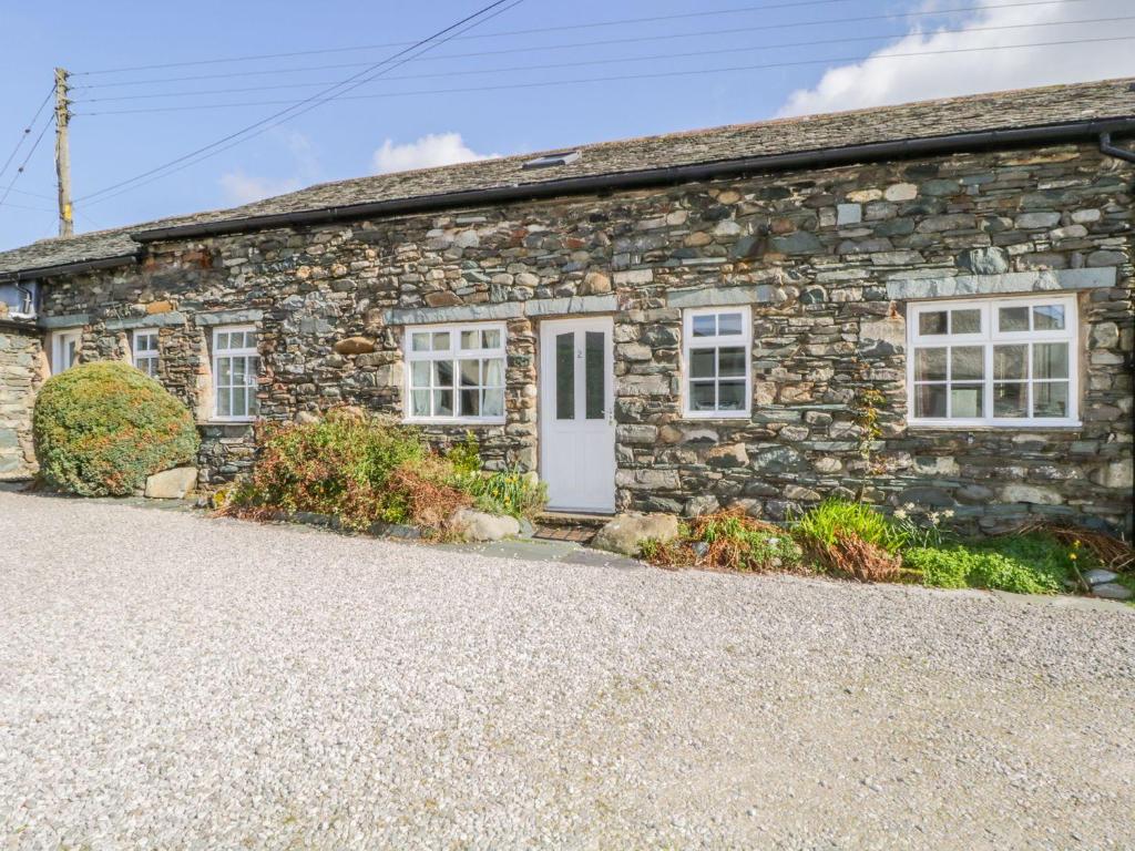 a stone house with a white door and windows at Cottage 2 in Keswick