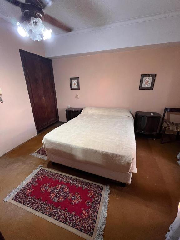 a bedroom with a bed and a red rug at La casa del recho in Santo Tomé