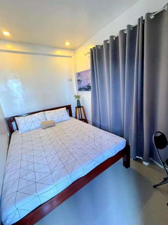 a bedroom with a large bed with a blue light at DJL Beach House - Bantayan Island in Patao