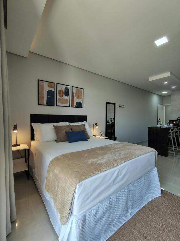 a bedroom with a large bed in a room at Studios Leme 11 - conforto para casal - com varanda in Espirito Santo Do Pinhal