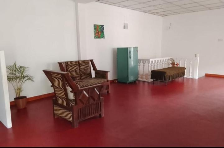 a living room with two chairs and a table at Thisu villa in Weligama