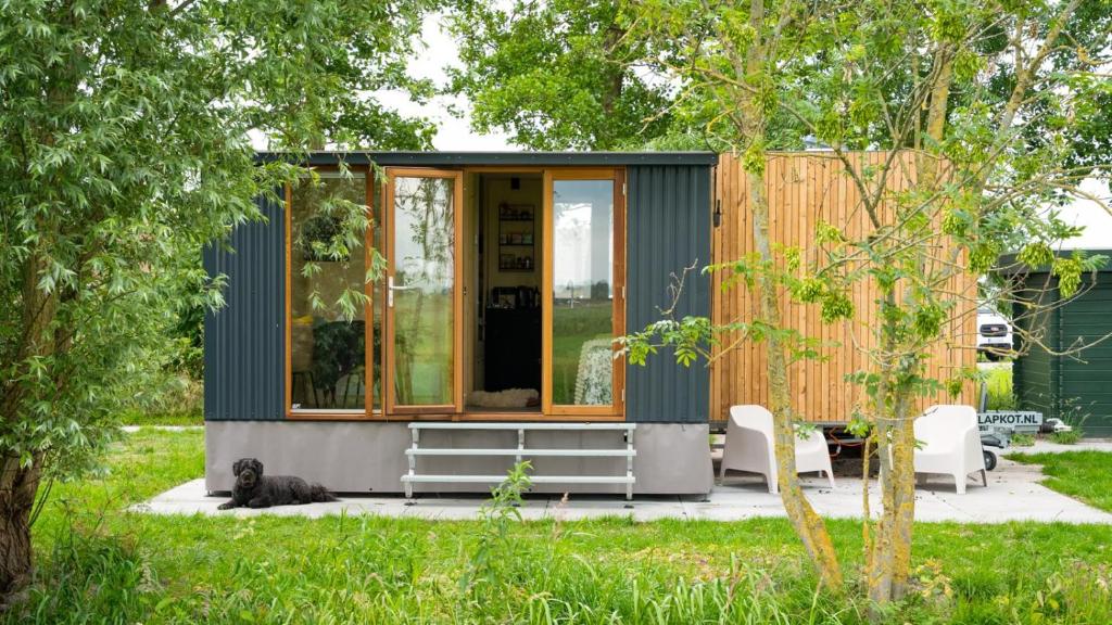 a tiny house with a cat sitting in front of it at Tinyhouse Polderpanorama in Haastrecht
