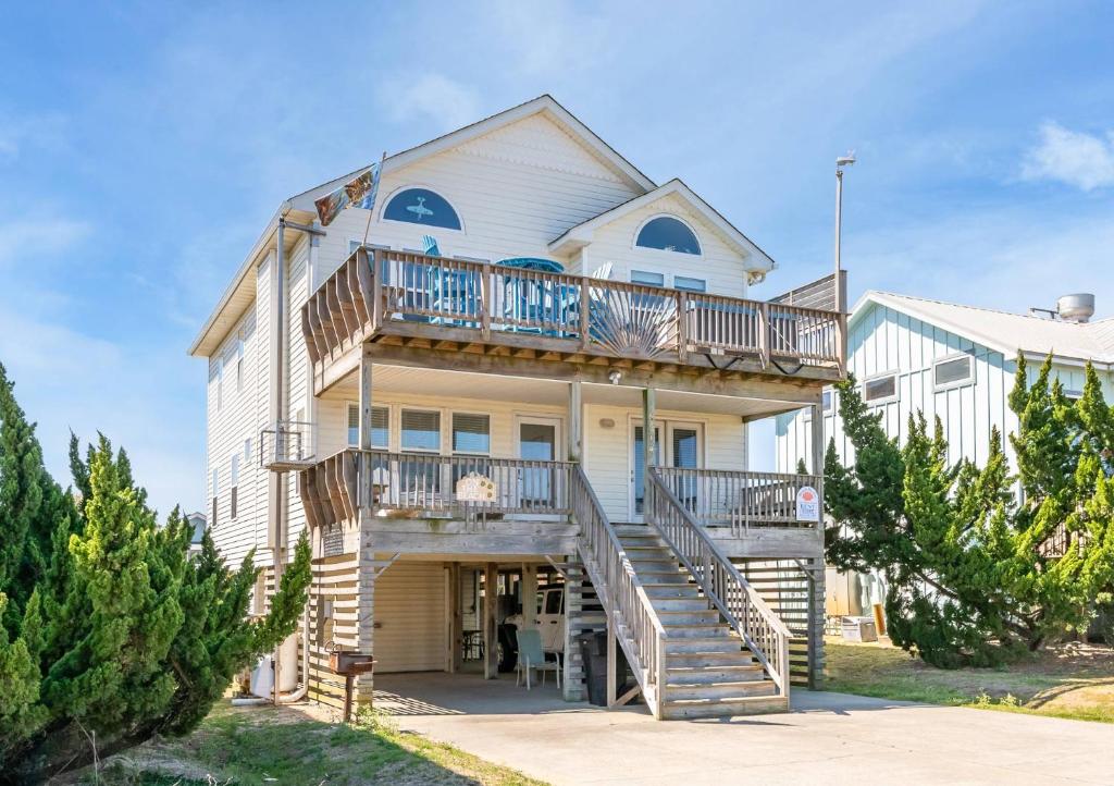 a large white house with a balcony and stairs at On The Beach - Kitty Hawk, MP 1, Less than 50 Yards to Beach, Ocean View, Pool, Hot Tub, Pets OK in Kitty Hawk