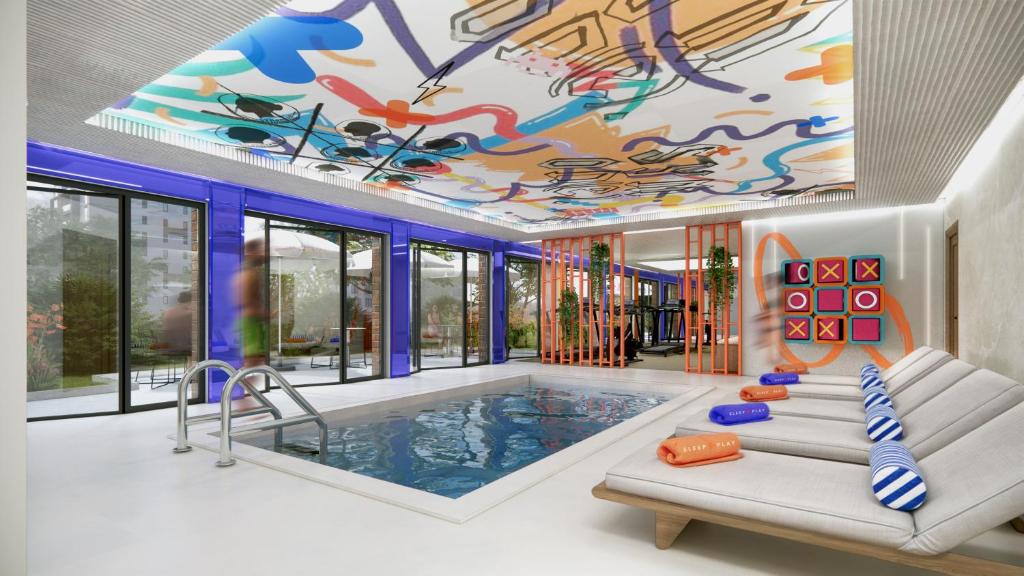 a pool in a house with a ceiling covered in graffiti at Symone - Poitiers in Poitiers