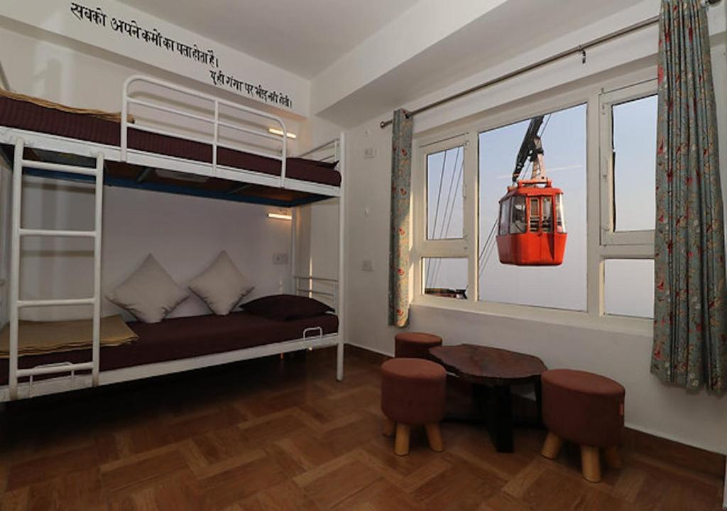 a bedroom with a bunk bed and a table and chairs at help hostel in Mussoorie