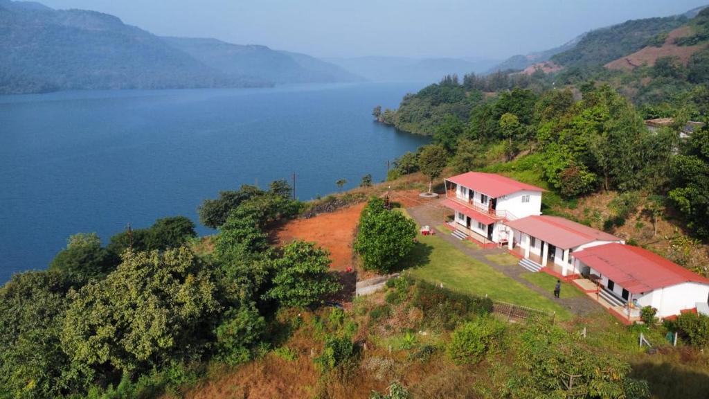a house on a hill next to a body of water at Blue Mountain Resorts in Lavasa