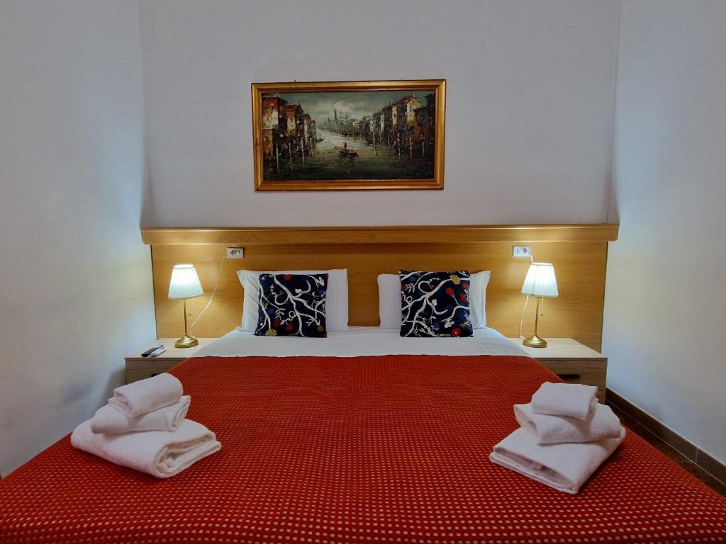 a bedroom with a large bed with towels on it at Hotel Tito in Mestre