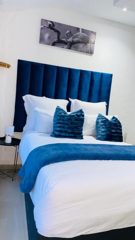 a large blue and white bed with pillows on it at Fourways Luxury Residence in Four Ways