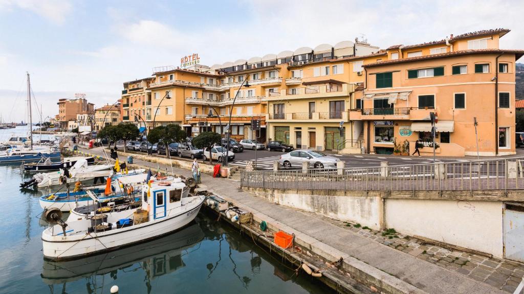 ein Boot, das in einem Yachthafen vor Gebäuden angedockt ist in der Unterkunft Cav Approdo in Castiglione della Pescaia