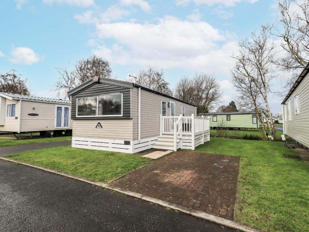 a tiny house is parked in a yard at Hadrian's Rest Glendale Holiday Park in Wigton
