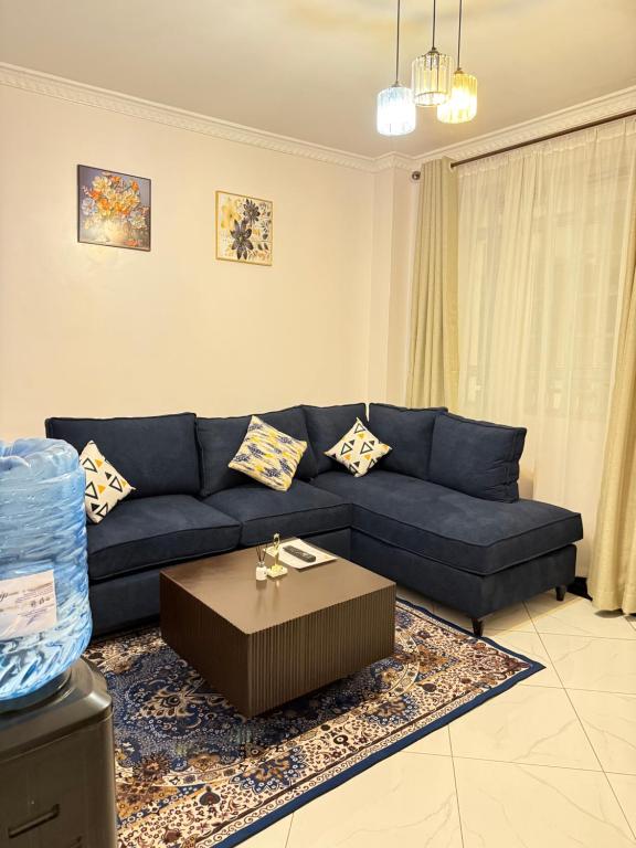 a living room with a blue couch and a coffee table at Beytumn Executive Apartment in Ruiru