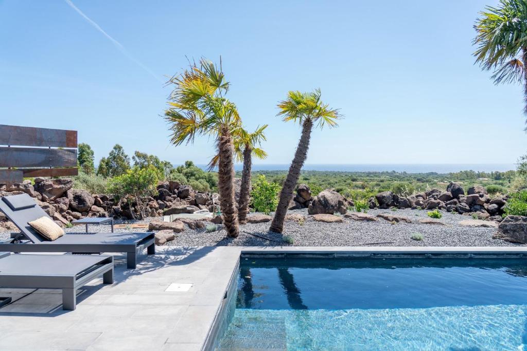 a swimming pool with palm trees and a resort at Casa Arim in Orosei