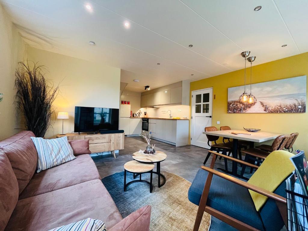 a living room with a couch and a table at It Winkelhûs in Terschelling