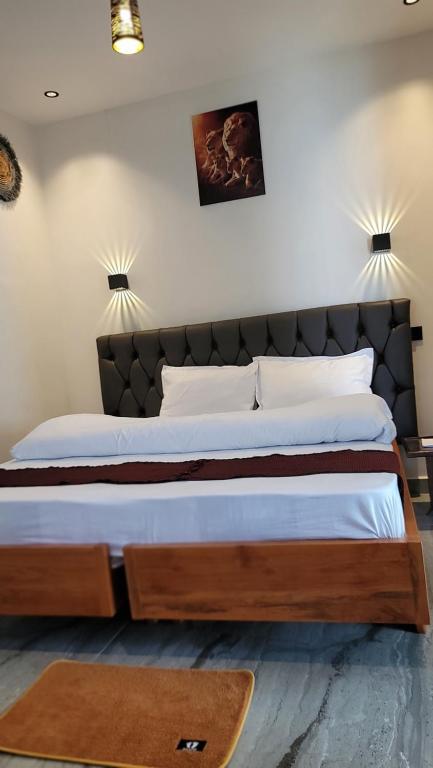 a bedroom with a large bed with a wooden headboard at Ashe Oleng House in Arusha