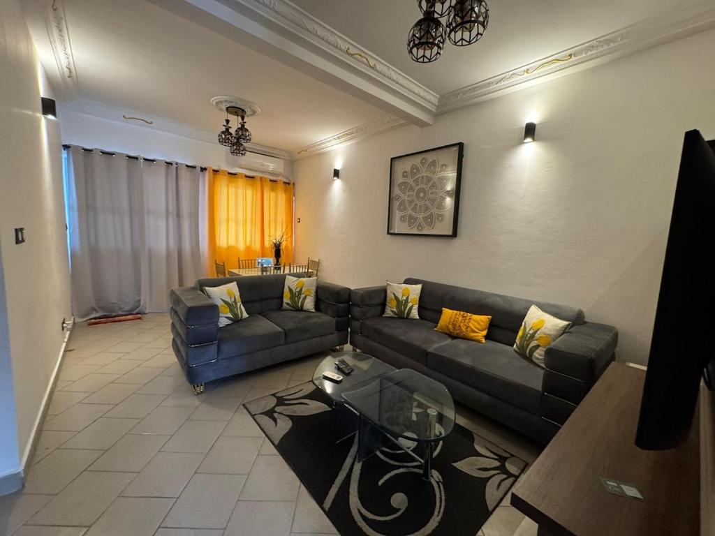 a living room with a couch and a table at Appartement moderne et épuré in Bonabéri