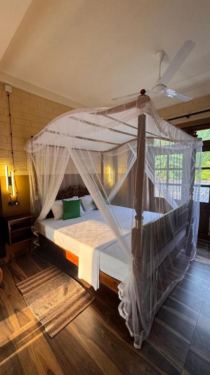 a bedroom with a bed with a mosquito net at WILD PARADISE Apt in Unawatuna