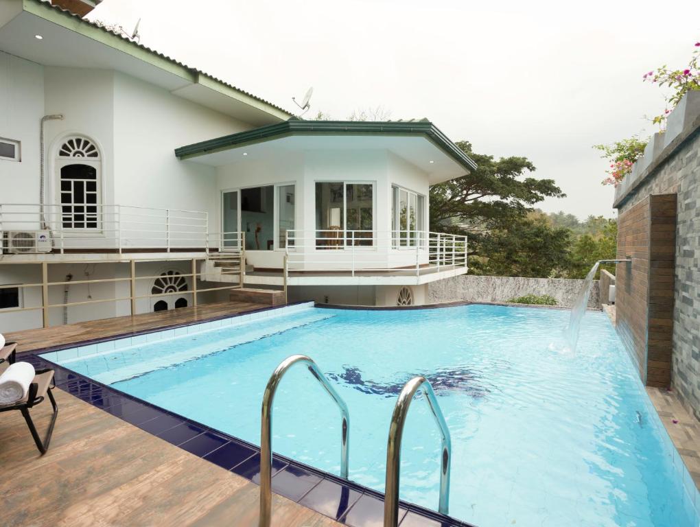 a large swimming pool in front of a house at Winter Villa in Kandy