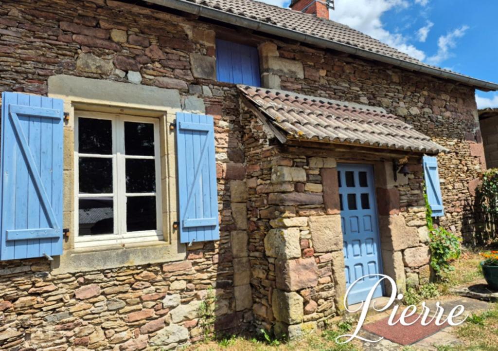 an old stone house with blue shutters and a window at Gîte Pierre, Beynat, Corrèze in Beynat