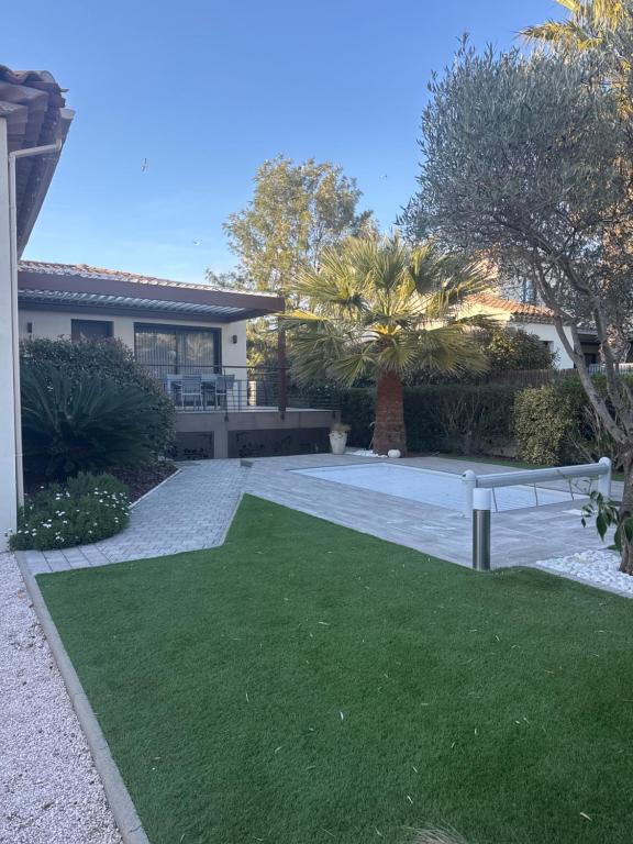 a yard with a bench in front of a house at VILLA TRANQUILLE in Fréjus