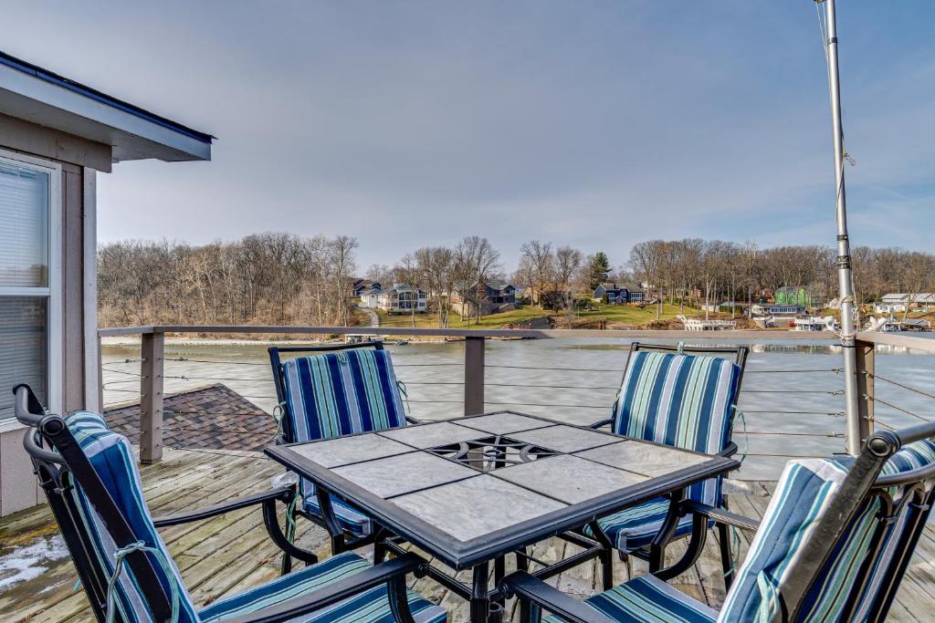 a table and chairs on a deck with a view of the water at 3 Mi to Dtwn Monticello! Waterfront Studio Getaway in Monticello