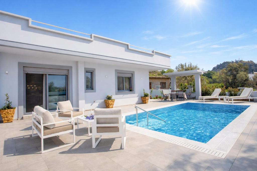a villa with a swimming pool and a patio at The Sisters Villa in Kalithies
