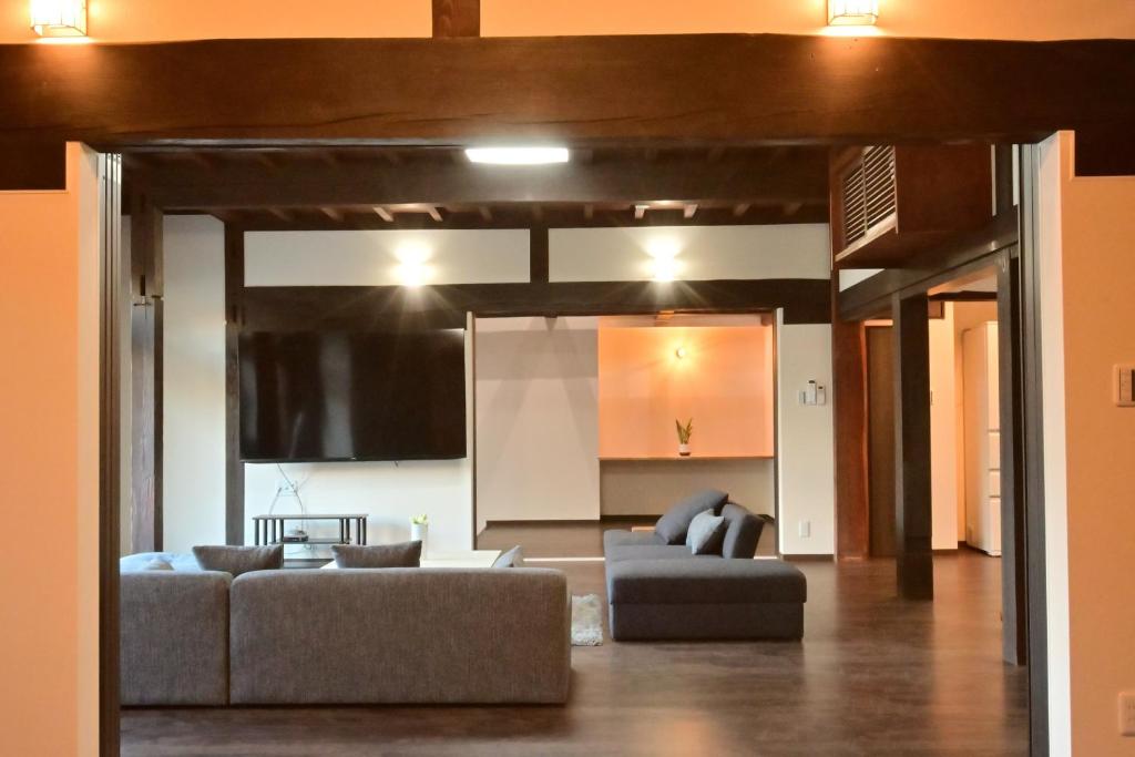 a living room with two couches and a tv at 愛敬家 in Mobara