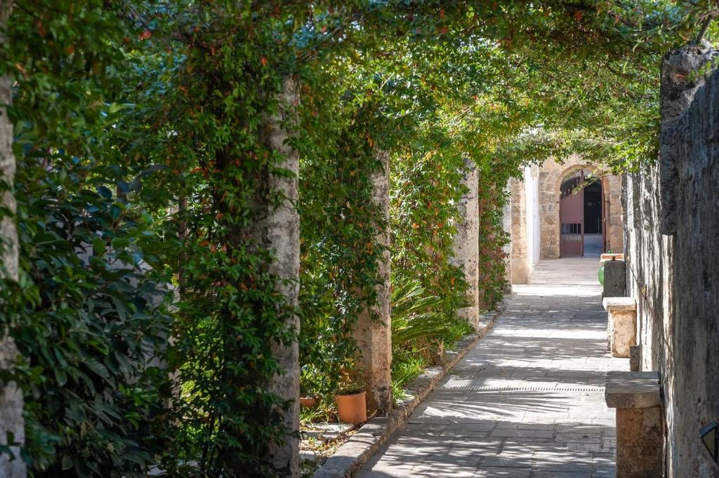 an alley with trees and an arch way at Corte Piri in Tricase