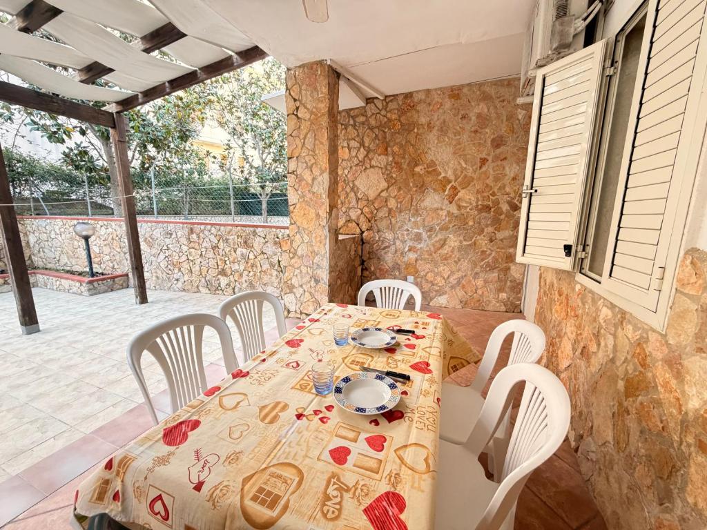 a dining room with a table and white chairs at Baia Incantata in Baia Verde