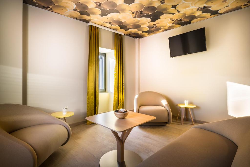 a room with a couch and a table and a tv at Hotel Vinotel Gospoja in Vrbnik