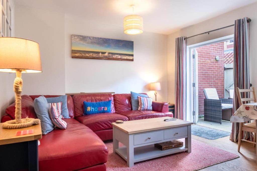 a living room with a red couch and a table at 4 Bed in Cromer oc-1942 in Cromer