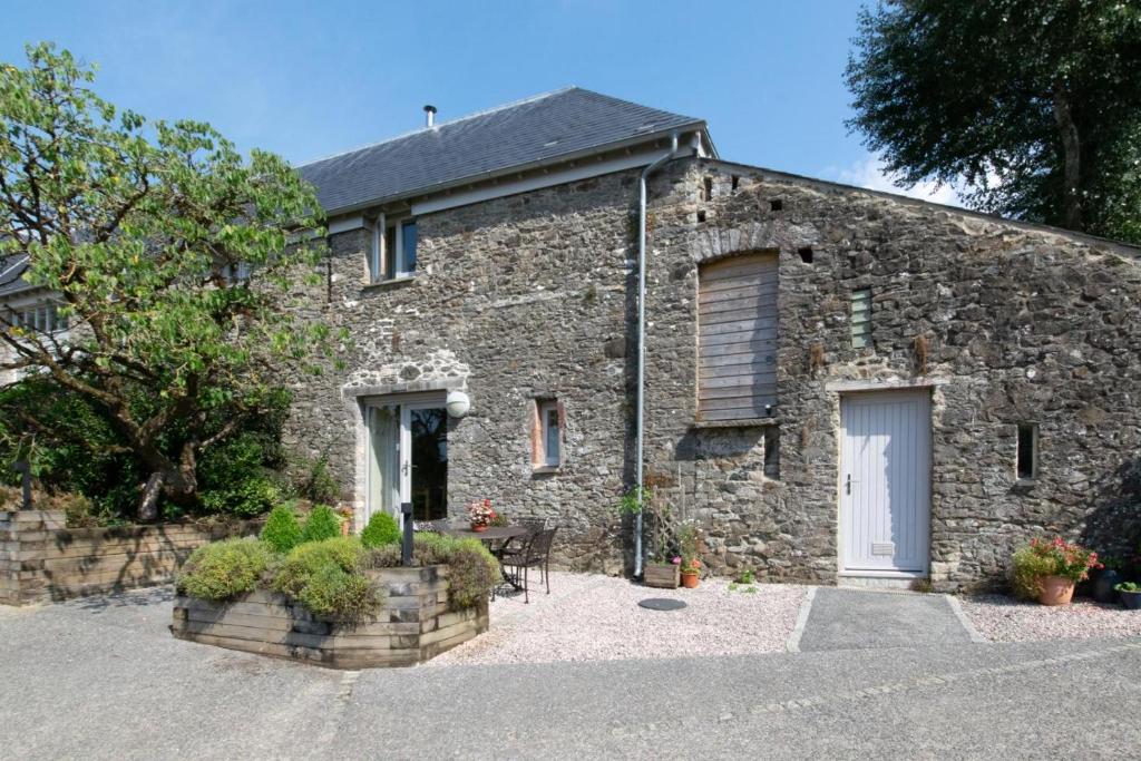 an old stone house with a white door at 2 Bed in Totnes oc-bcteig in Broadhempston