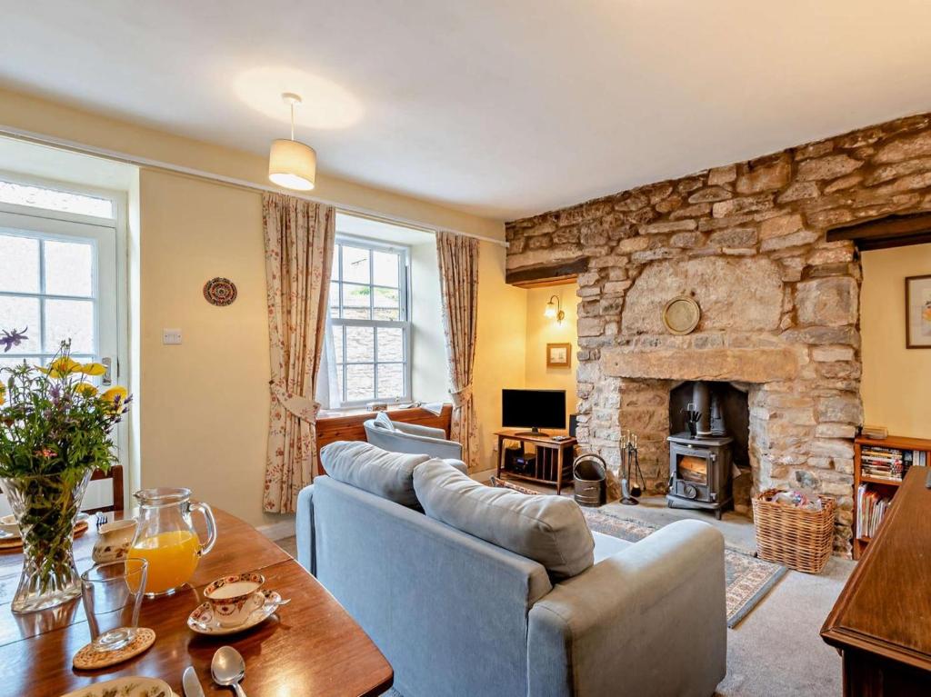a living room with a couch and a stone fireplace at 2 Bed in Kirkby Stephen oc-sz144 in Kirkby Stephen